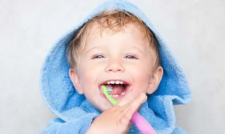 Dentista de la Seguridad Social: 5 tratamientos gratis que te ocultan 7 Niño sonriendose lavándose los dientes