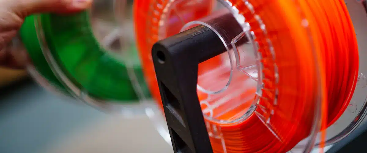Fabricación aditiva: qué es la impresión 3D industrial y para qué se utiliza 6 Bobinas de filamento de varios colores junto a herramientas de impresión tridimensional