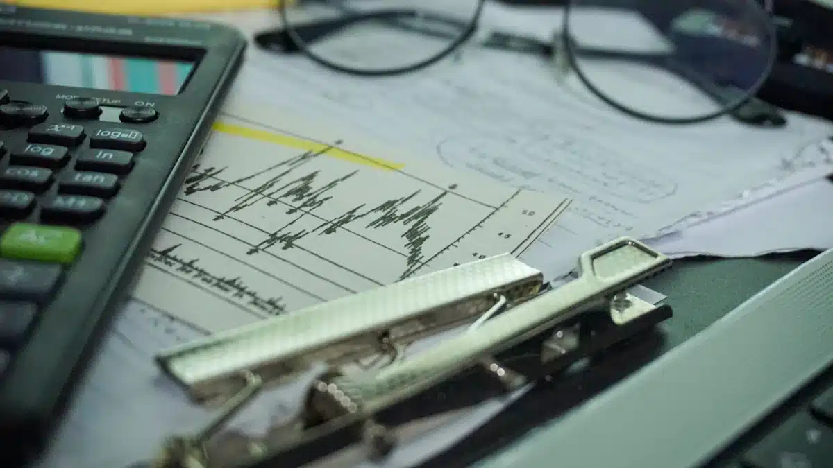 Calculadora, documentos y gafas preparados sobre una mesa de trabajo