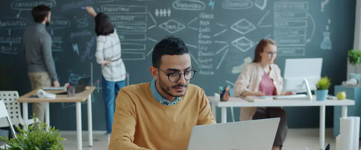 Desarrollo de aplicaciones móviles: fases, tecnologías y costes 8 Desarrollador concentrado trabajando con su ordenador en una oficina colaborativa