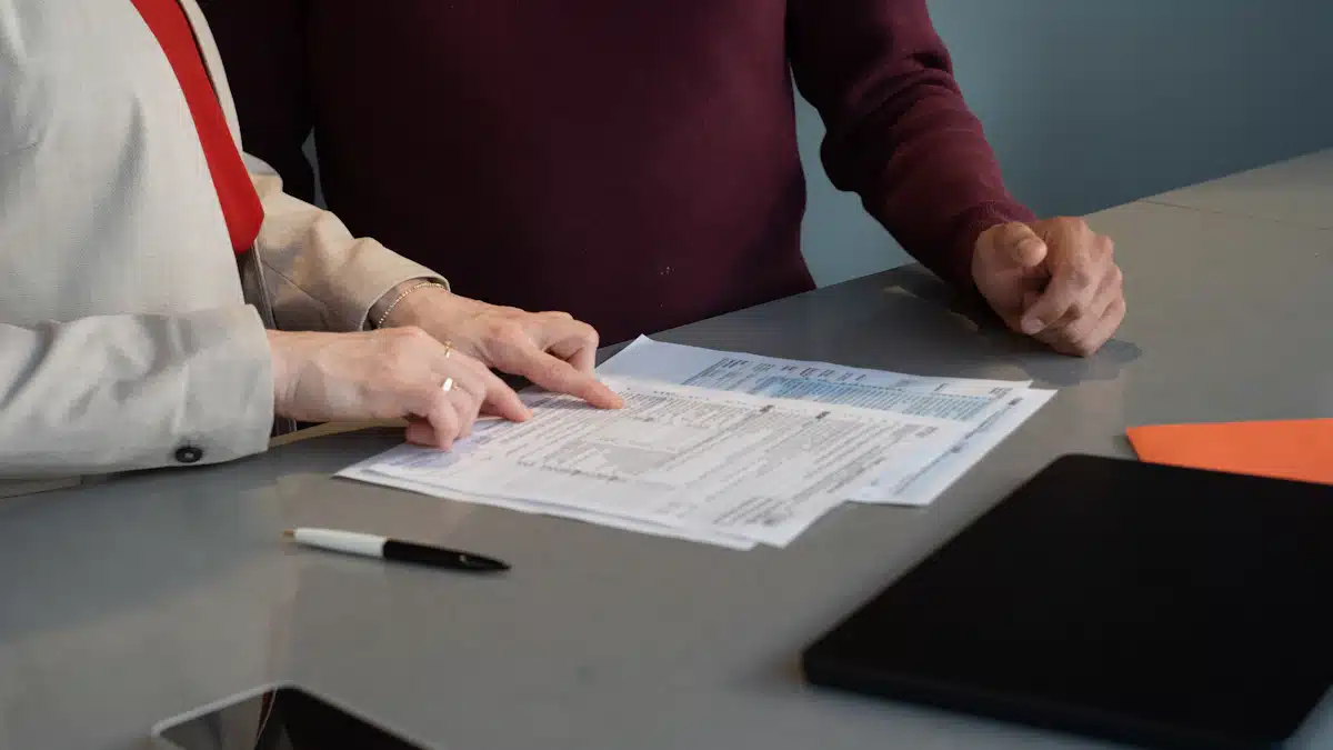 Analítica web: cómo medir el rendimiento de una página web 9 Dos personas revisan documentos e indicadores comerciales sobre una mesa de reuniones