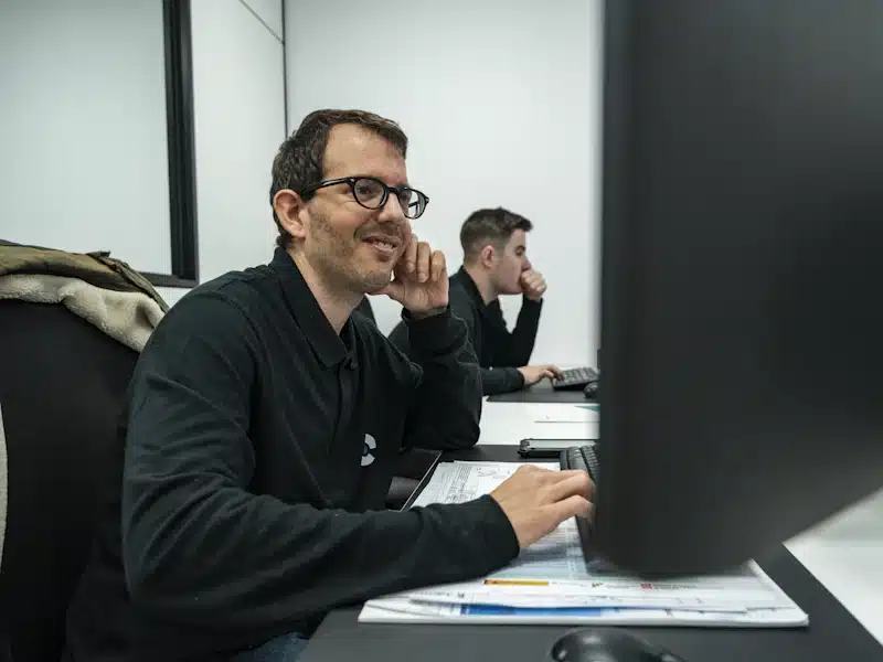 Oficina técnica: qué es, funciones y cómo gestionar proyectos 3 Dos técnicos trabajan con ordenadores y documentación en una oficina industrial