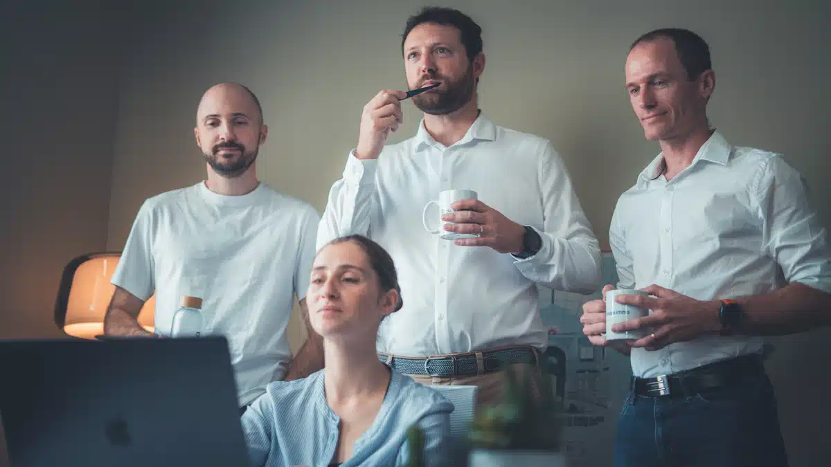 Computación en la nube: cómo funciona y qué ventajas ofrece a las empresas 4 Equipo empresarial reunido frente a un portátil para planificar mejoras tecnológicas