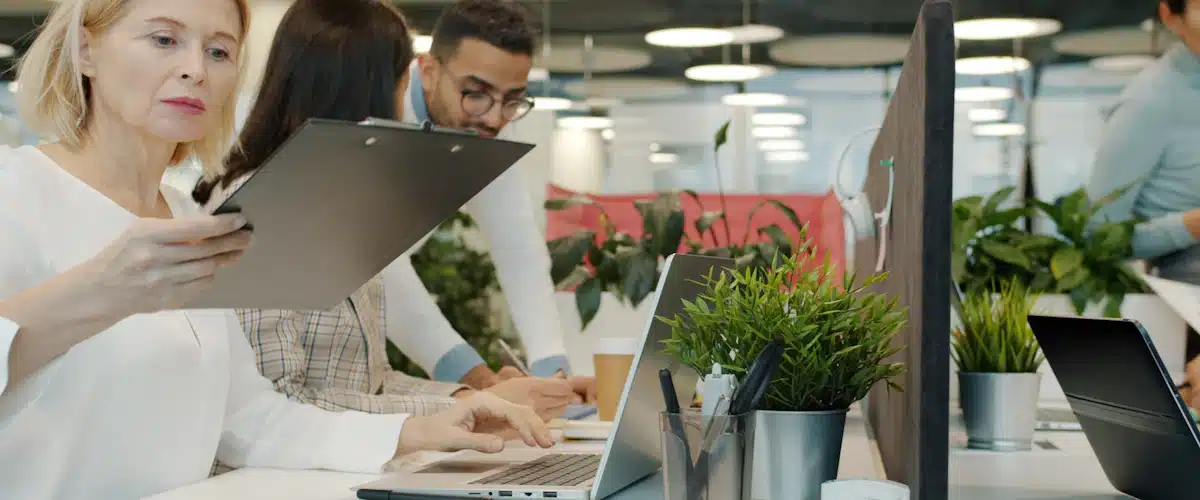 Desarrollo de aplicaciones móviles: fases, tecnologías y costes 7 Equipo profesional revisando tareas y resultados alrededor de varios ordenadores
