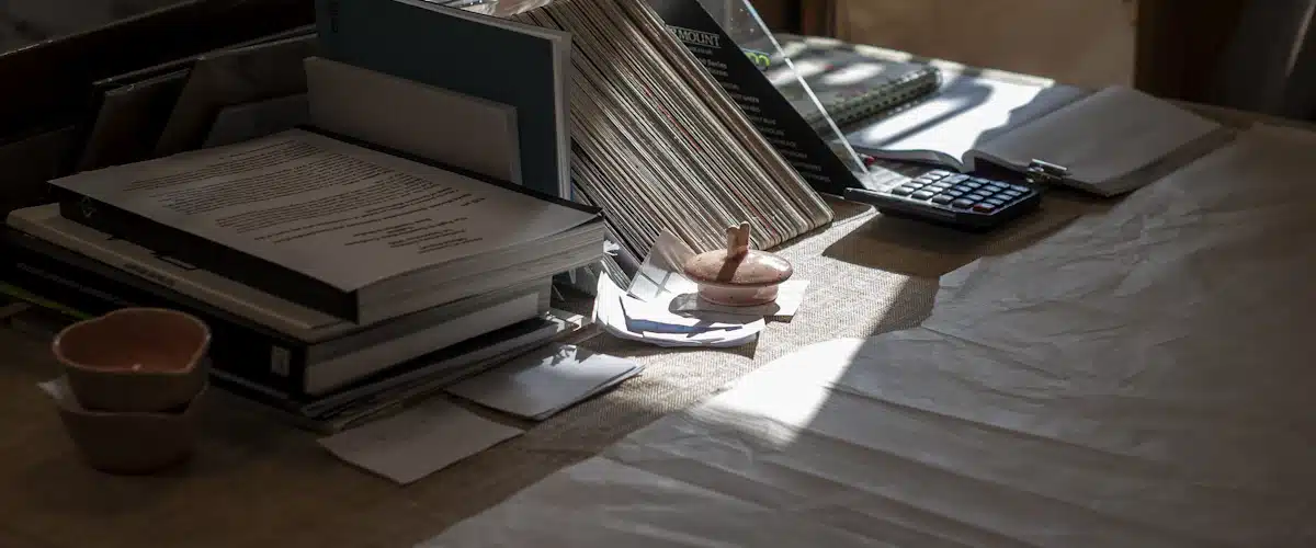 Libros, papeles y calculadora organizados sobre un escritorio de oficina