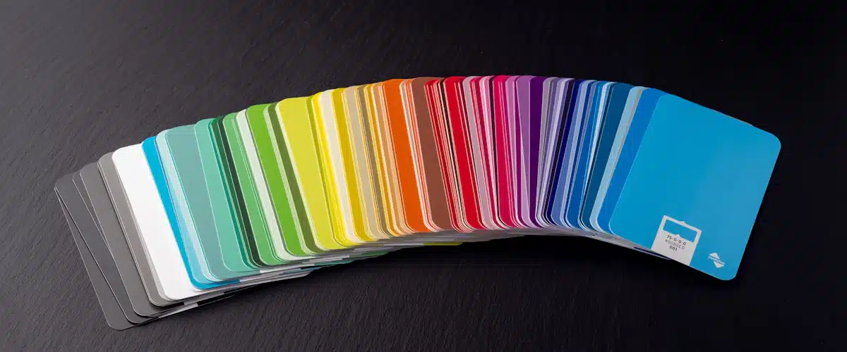 Diseño editorial: cómo planificar una publicación profesional 8 Muestrario de colores impresos desplegado en abanico sobre una mesa