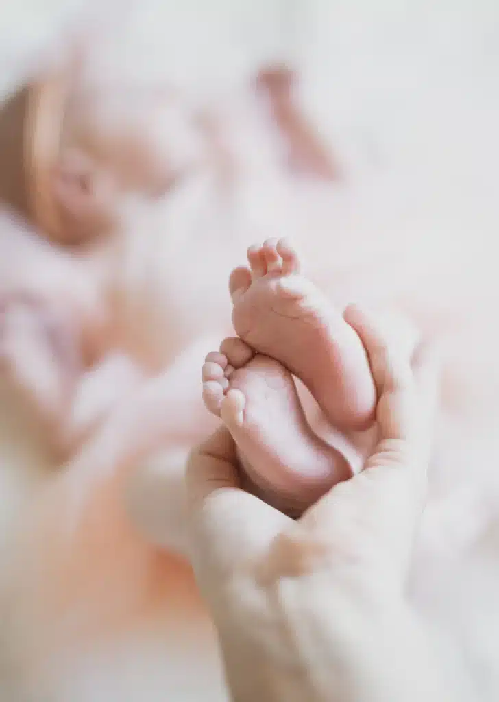 100 nombres de niña con significado: ideas para elegir en 2026 8 Manos sujetando con cuidado el pie de un bebé