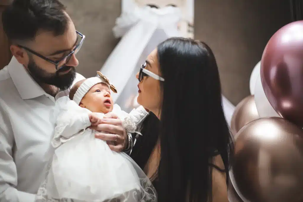 100 nombres de niña con significado: ideas para elegir en 2026 2 Padres sosteniendo a su bebé mientras valoran nombres de niña