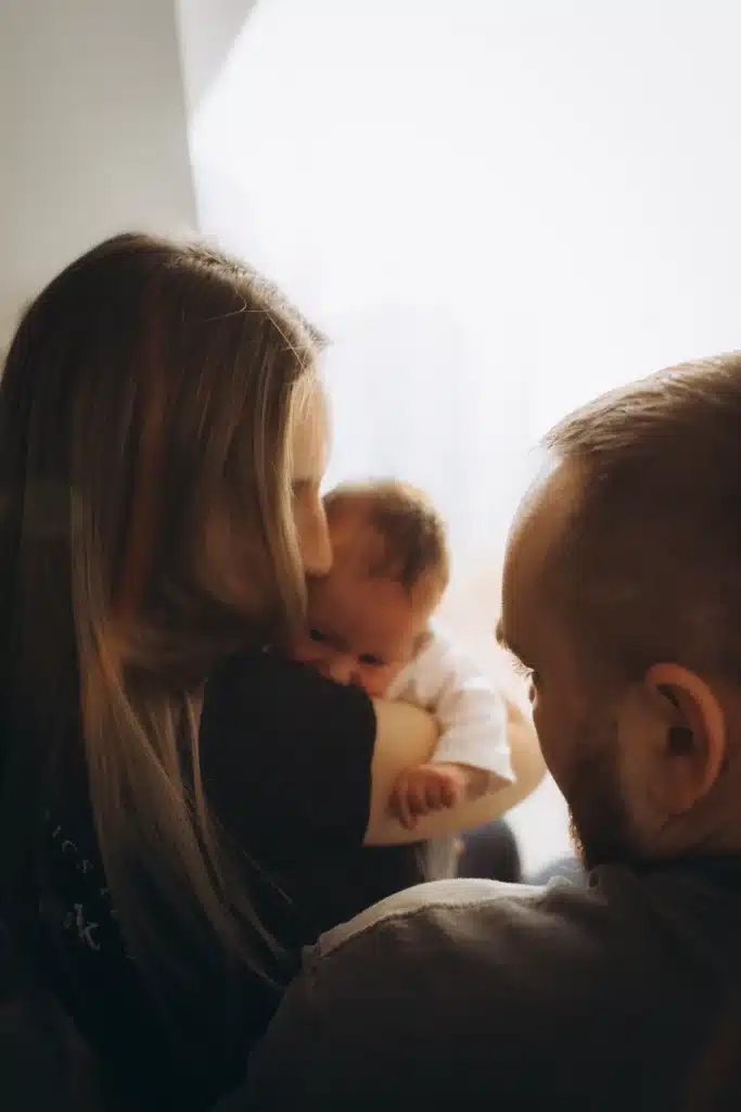 100 nombres de niña con significado: ideas para elegir en 2026 3 Padres con un bebé recién nacido junto a una ventana