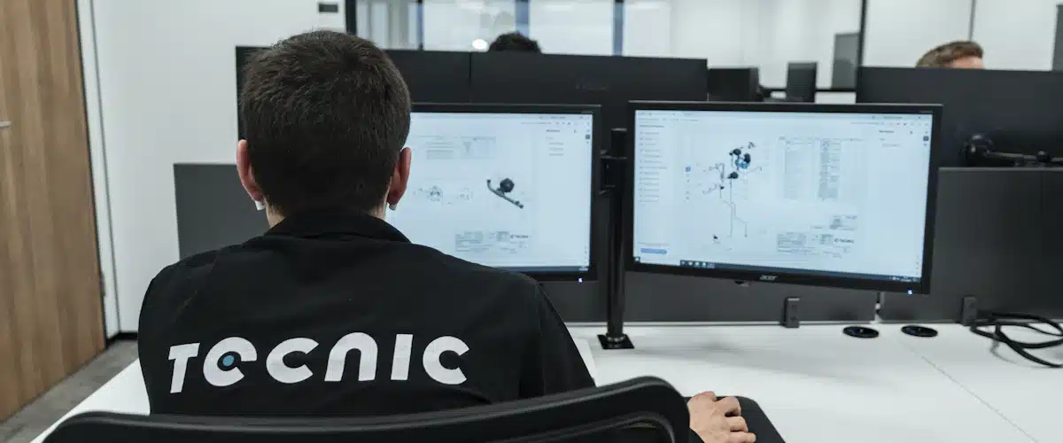 Oficina técnica: qué es, funciones y cómo gestionar proyectos 6 Profesional consulta dibujos técnicos en dos monitores de una oficina de ingeniería