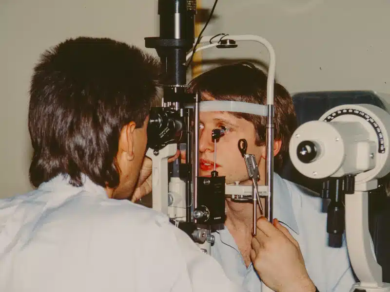 Lentes de contacto: tipos, cuidados y claves para gestionar una óptica 3 Profesional de la visión examinando un ojo con equipamiento clínico especializado