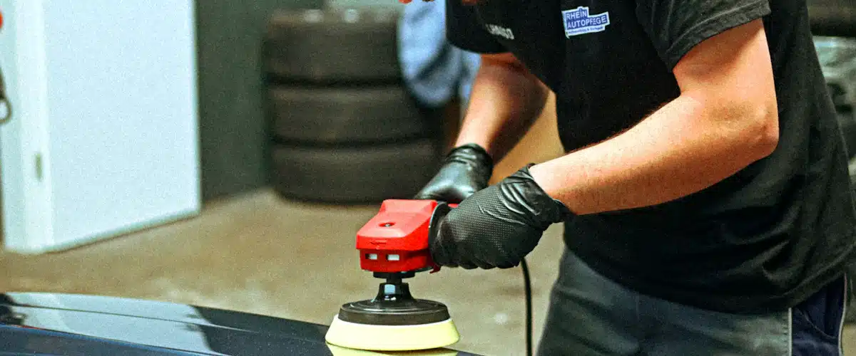 Chapa y pintura: 7 claves para un acabado perfecto 7 Profesional puliendo la carrocería oscura de un automóvil con herramienta eléctrica