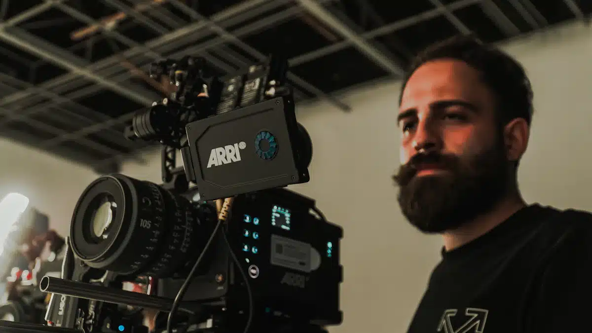 Producción audiovisual: fases, equipos y planificación de un proyecto 9 Profesional revisa una cámara de cine entre luces y personal técnico de estudio