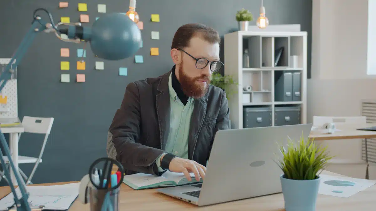 Email marketing: estrategias para captar y fidelizar clientes 9 Profesional trabajando concentrado con portátil y cuaderno en una oficina