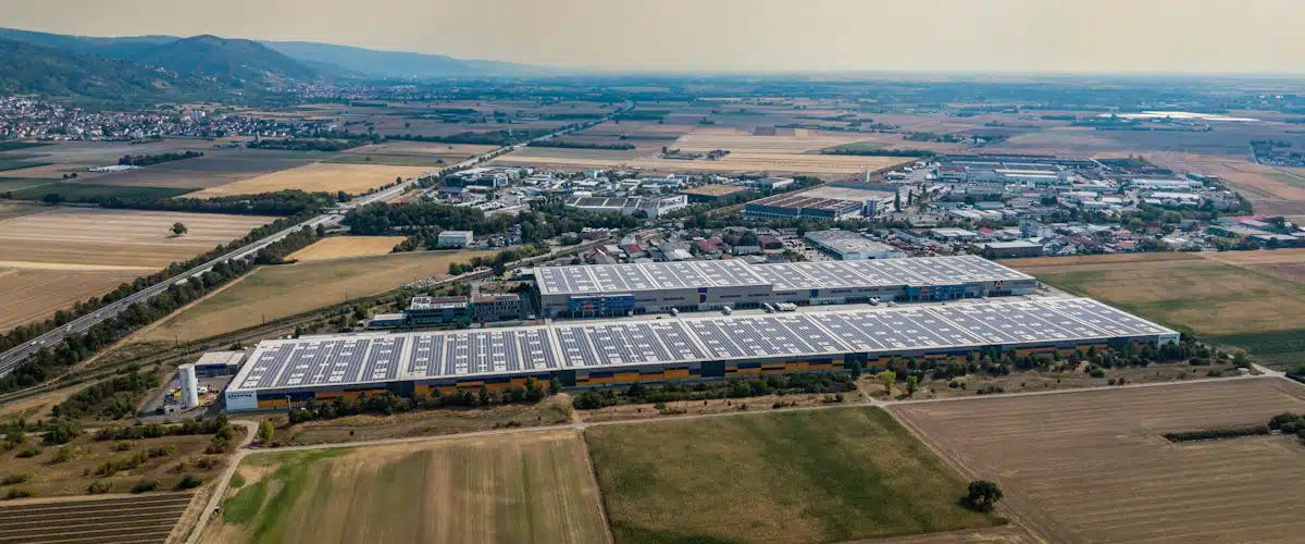Auditoría energética: qué es y cómo ayuda a reducir el consumo 8 Tejado de un almacén industrial cubierto por numerosos paneles solares fotovoltaicos.