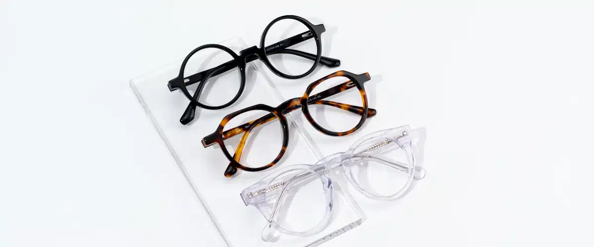 Lentes de contacto: tipos, cuidados y claves para gestionar una óptica 7 Tres modelos de gafas ordenados sobre una mesa blanca de exposición